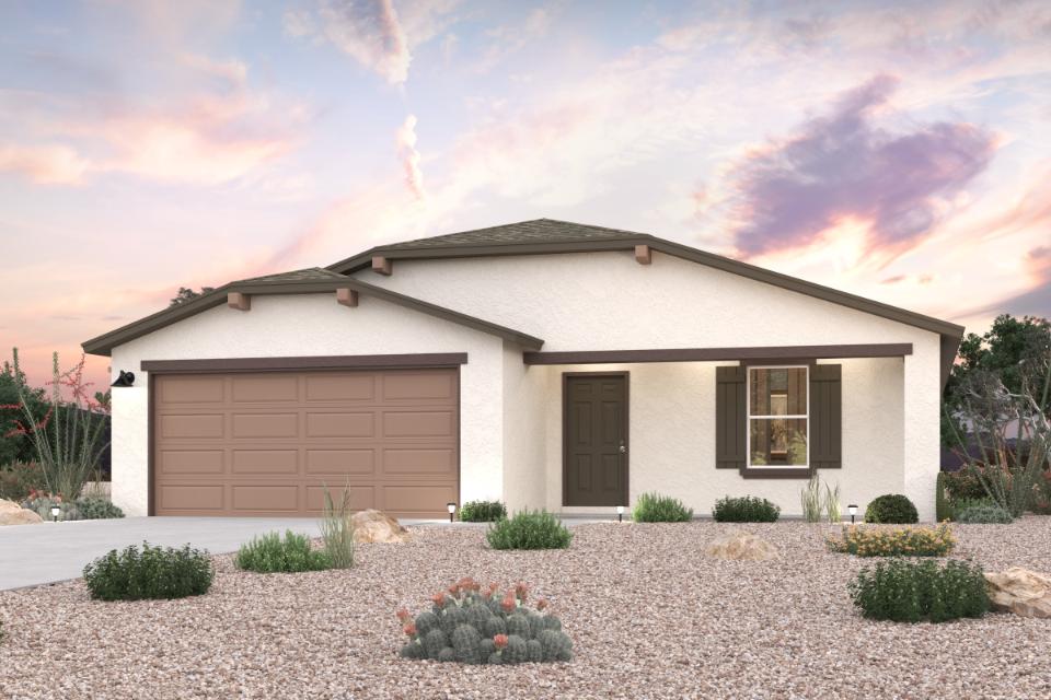 A house with a garage and bushes in front of it.