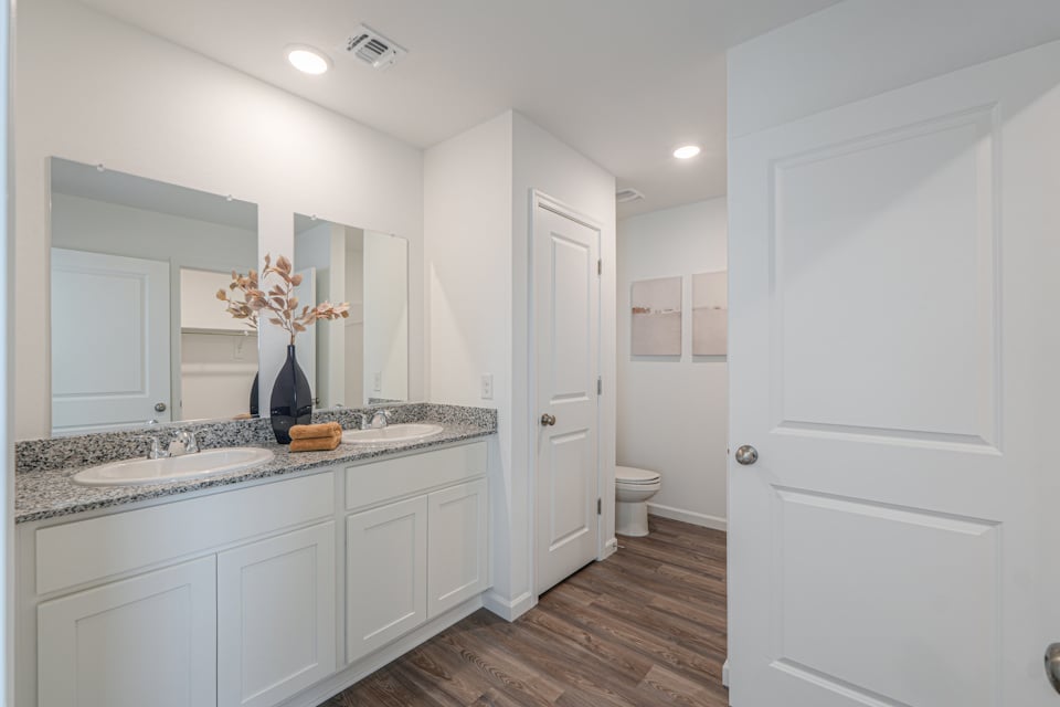 A bathroom with white cabinets.