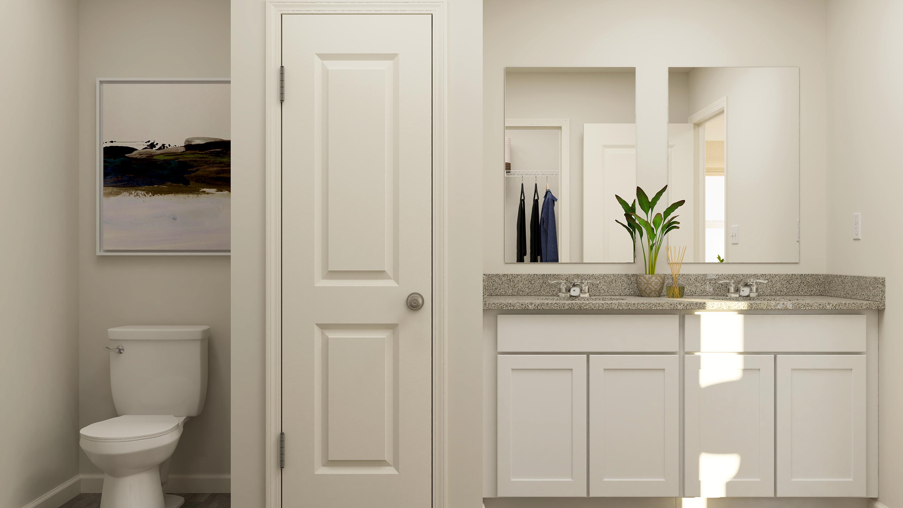 A bathroom with white cabinets.