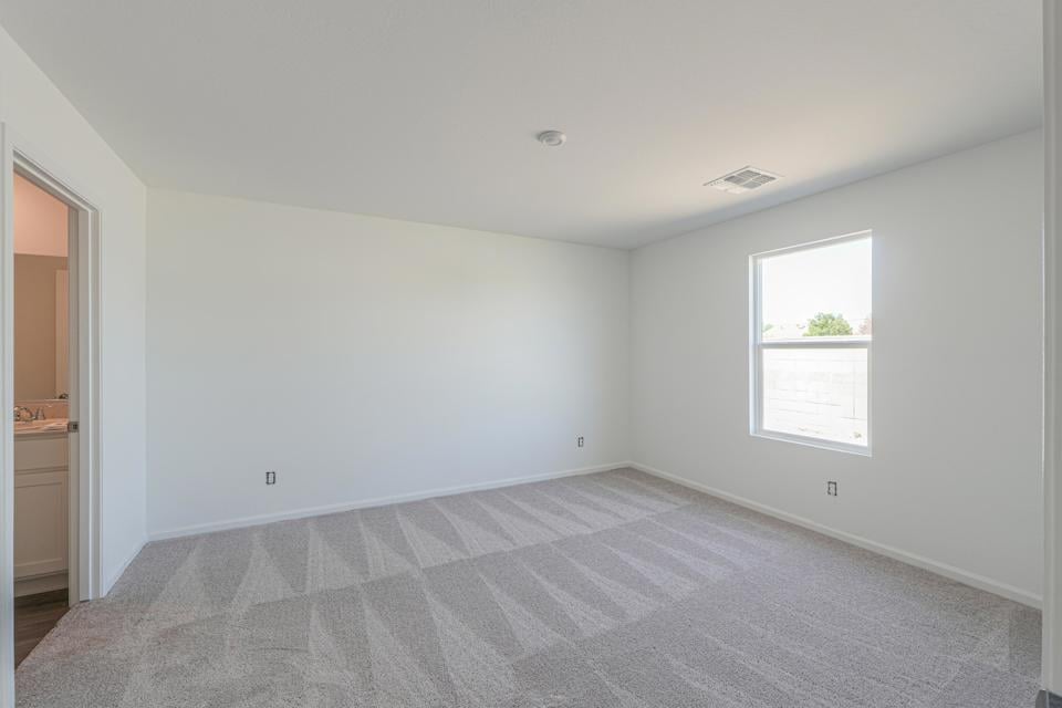 A room with a carpet and a window.