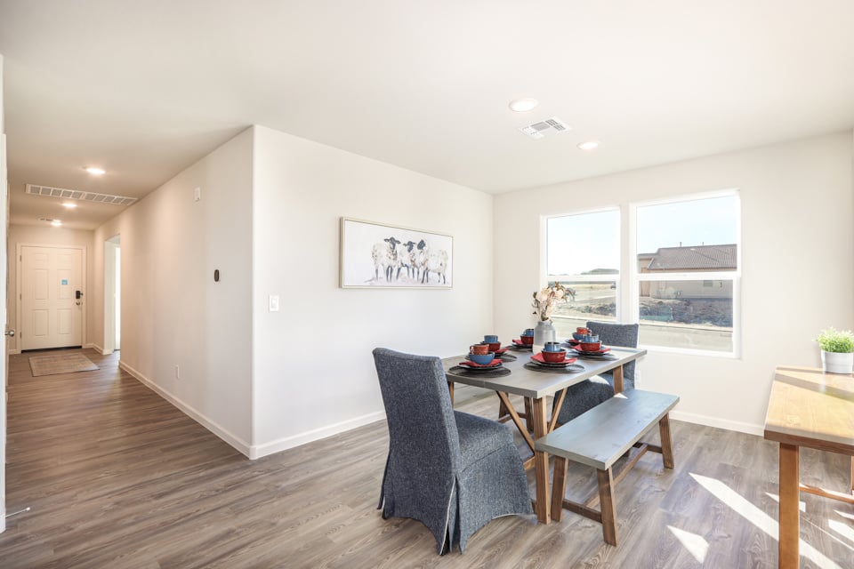 A room with a table chairs and a window.