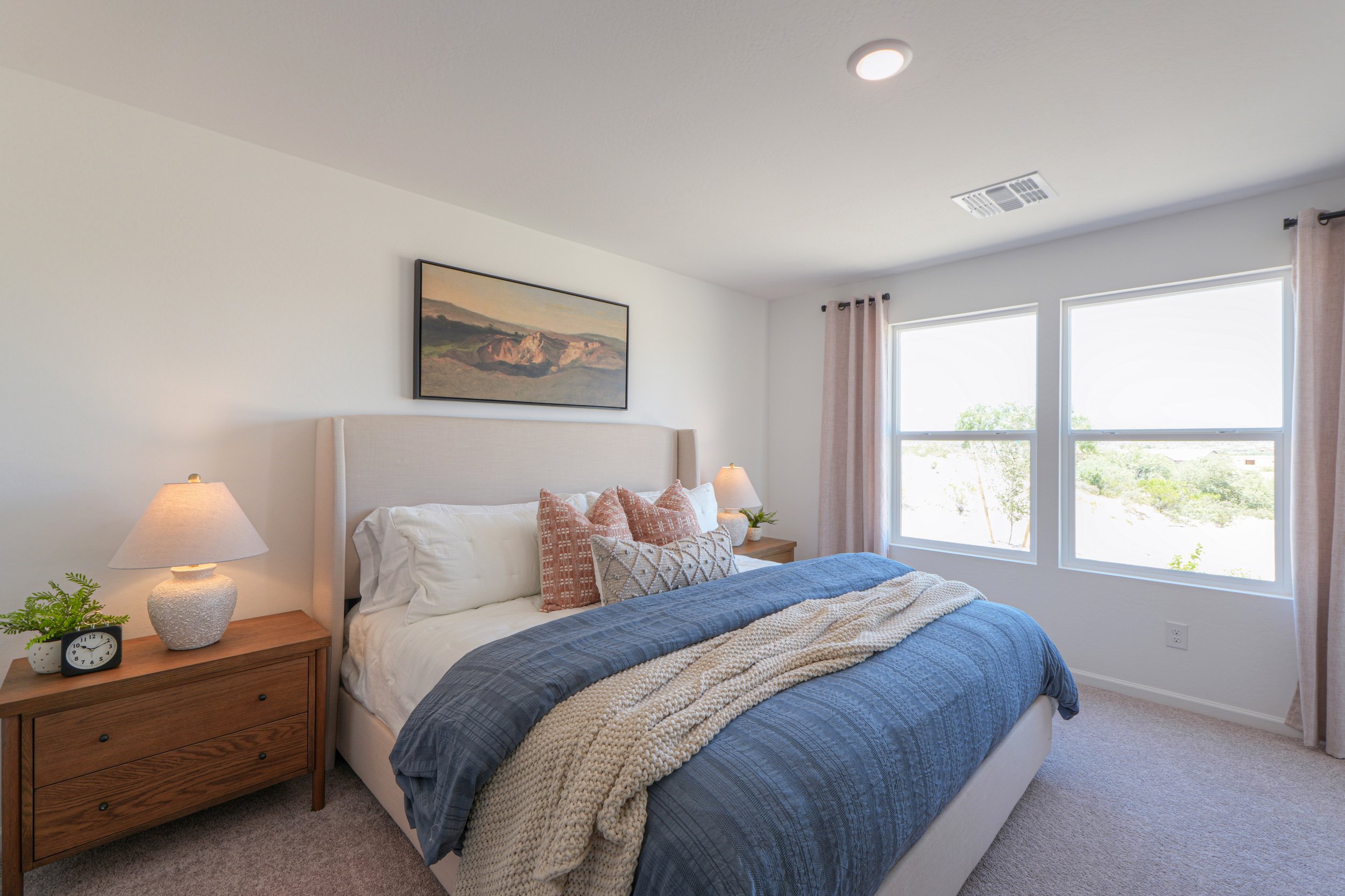 A bedroom with a bed and a lamp.