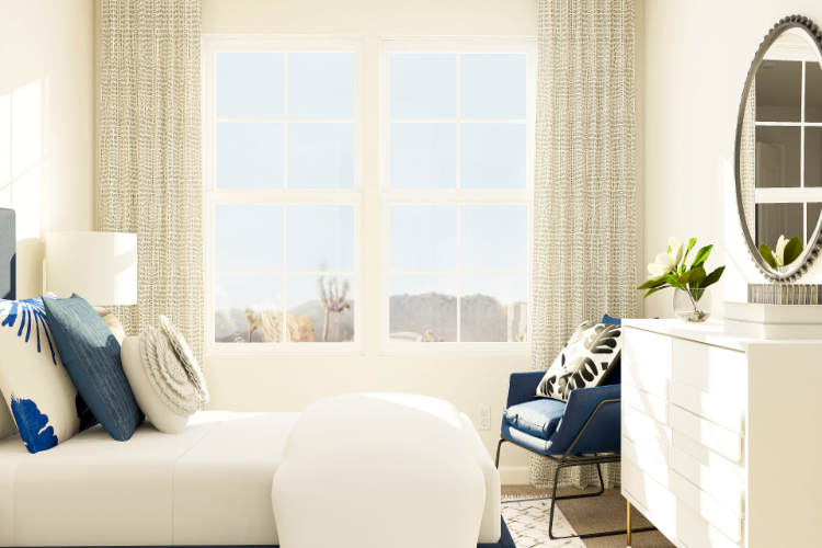 A room with a white couch and a window with a view of the city.