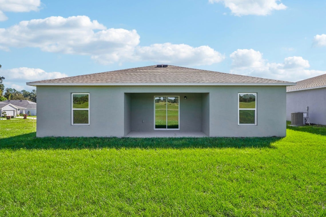 A white house with a grass yard.