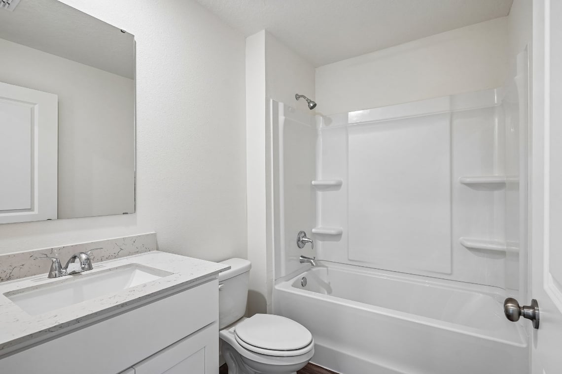 A bathroom with a tub sink and toilet.