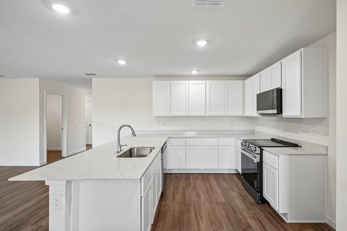A kitchen with white cabinets.