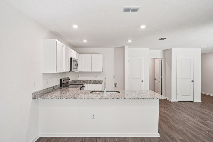 A kitchen with white cabinets.