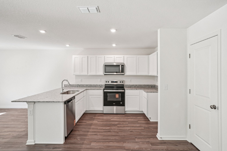 A kitchen with white cabinets.