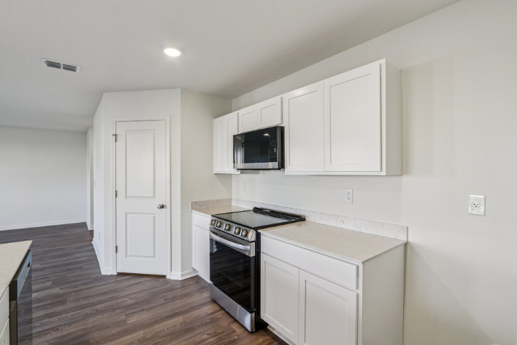 A kitchen with white cabinets.