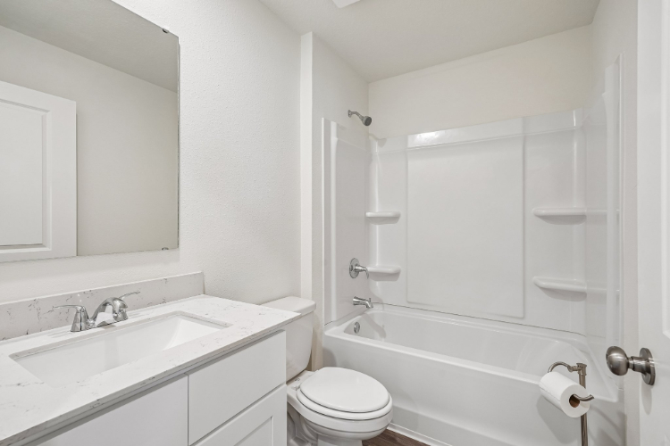 A bathroom with a tub sink and toilet.