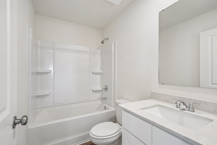 A bathroom with a tub sink and toilet.