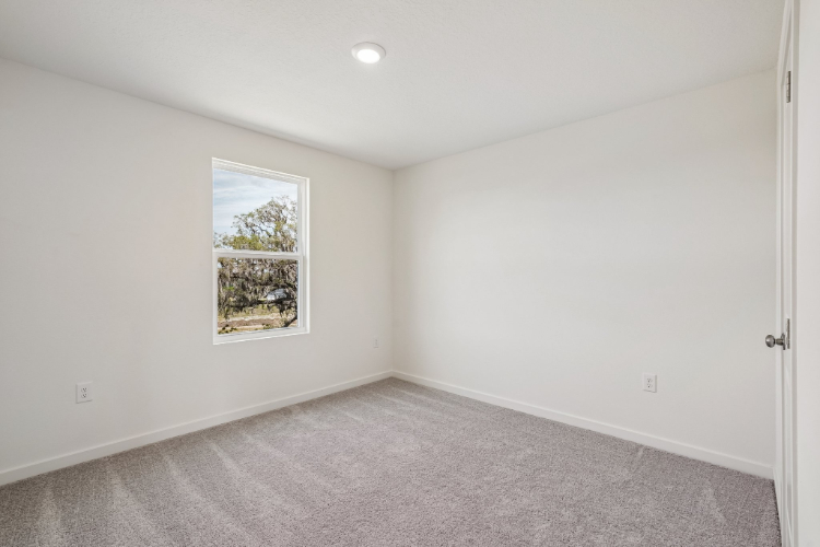 A room with a white wall and a window.