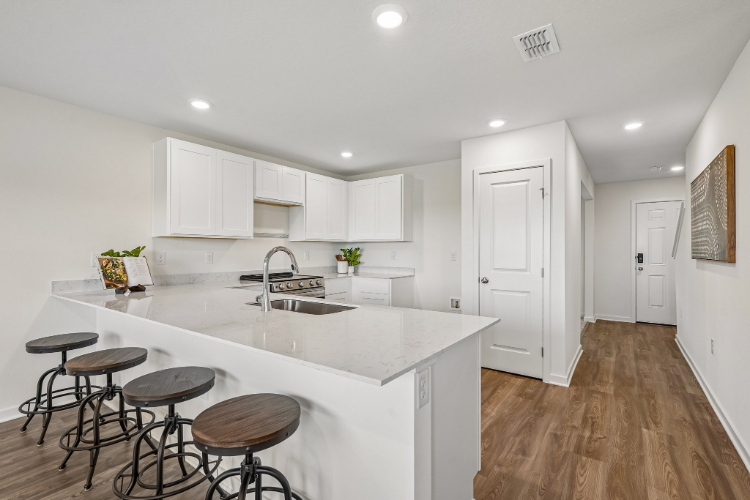 A kitchen with stools and a sink.