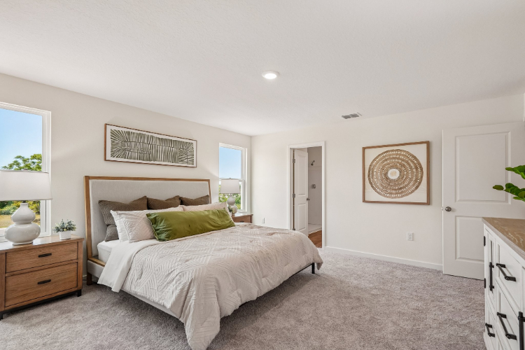 A bedroom with a bed and a lamp.