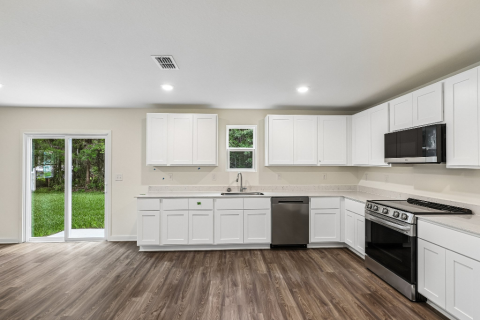 A kitchen with white cabinets.
