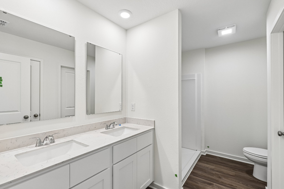 A bathroom with a sink toilet and mirror.