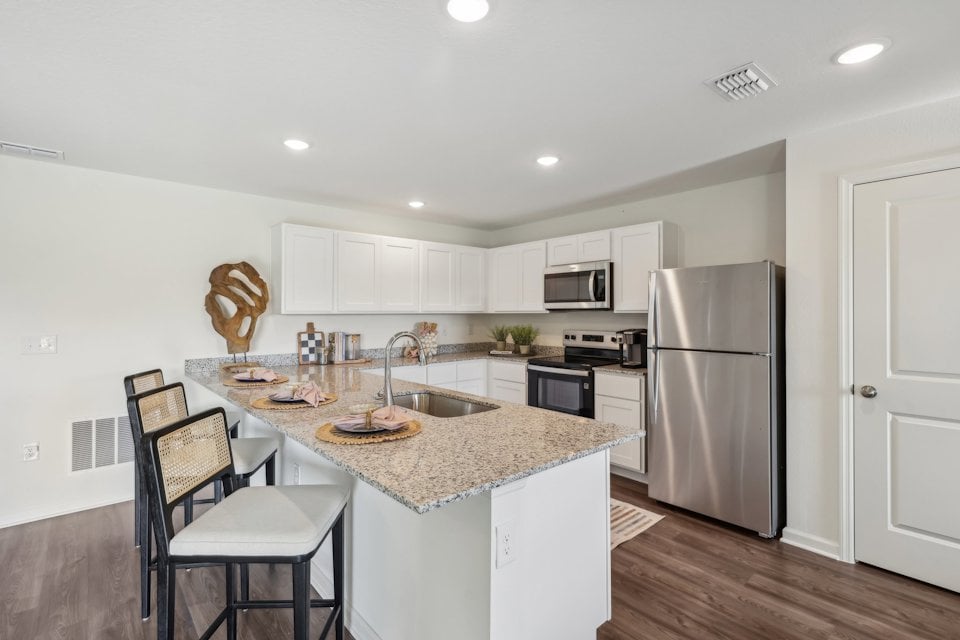 A kitchen with white cabinets.