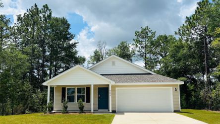 A house with a garage and trees with Mission House in the background.