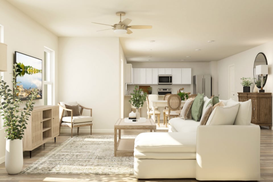 A living room with a white couch and a white table.