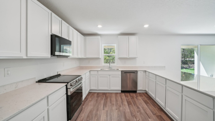A kitchen with white cabinets.