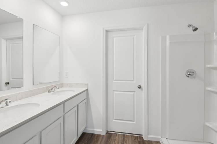 A bathroom with white cabinets.