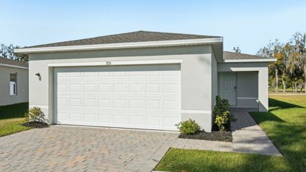 A white garage with a brick driveway.