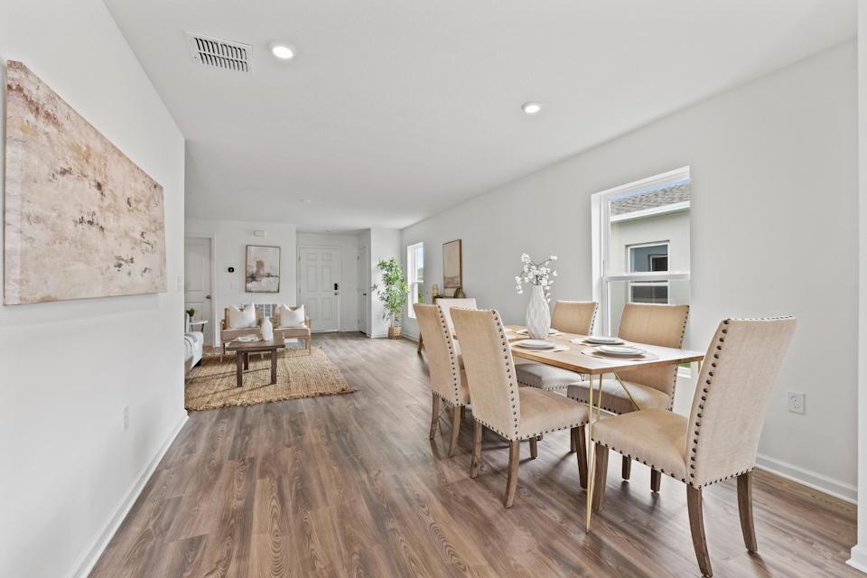 A dining room with a wood floor.