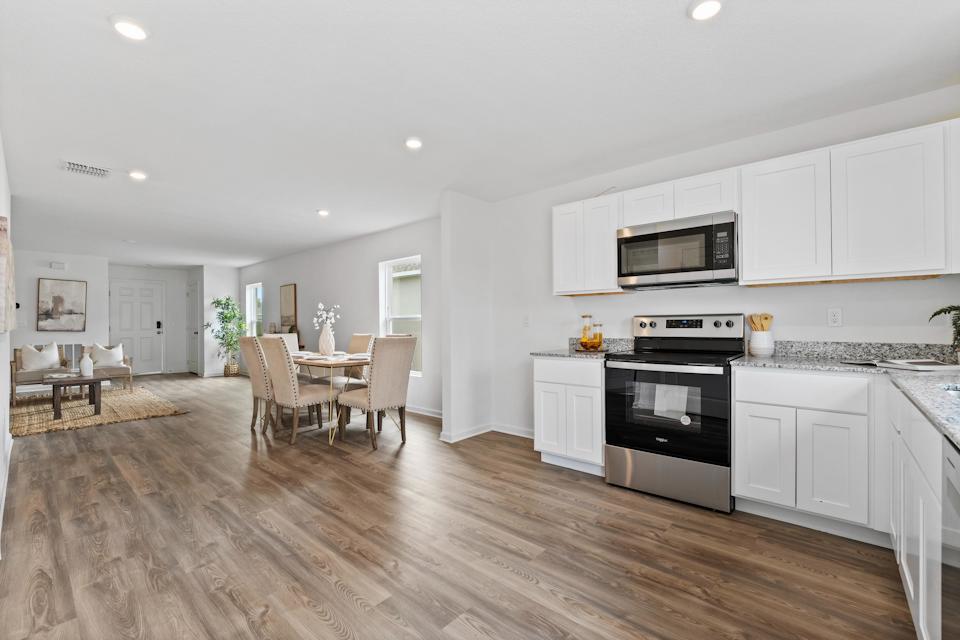 A kitchen with white cabinets.
