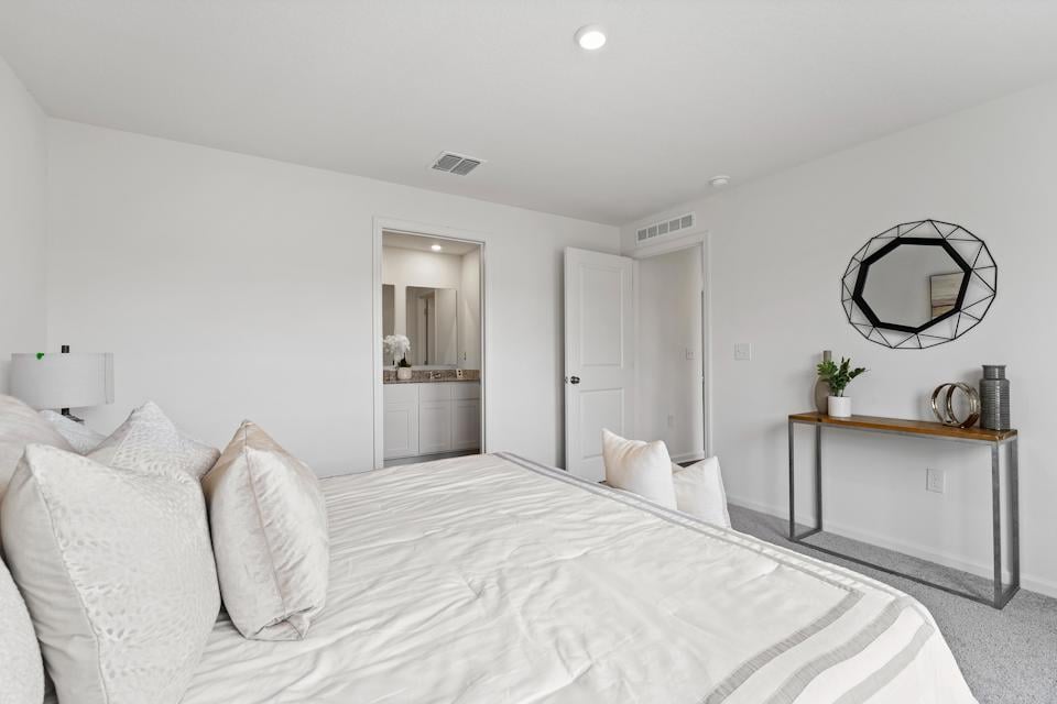 A bedroom with a bed and a mirror.
