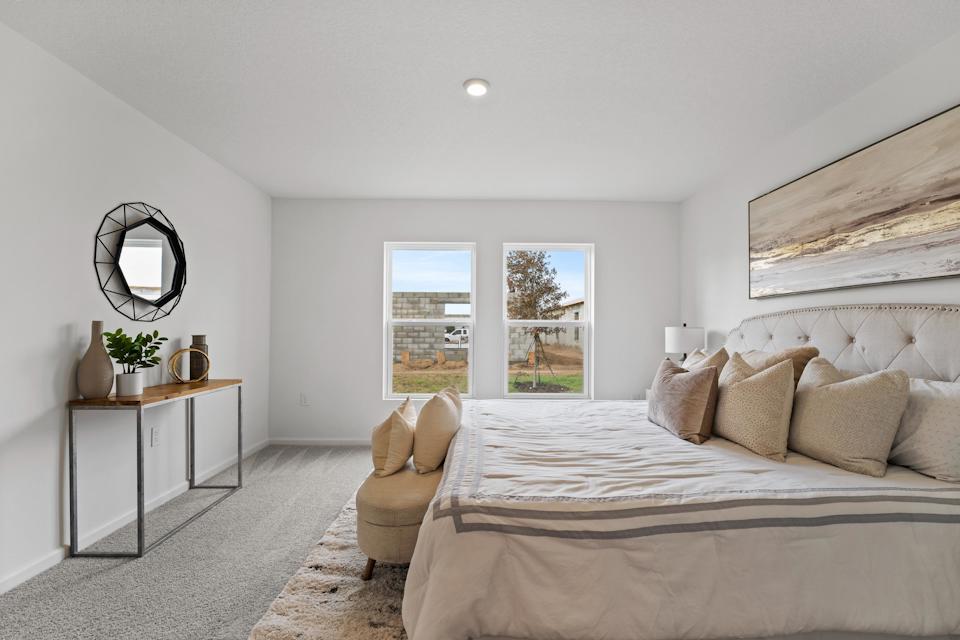 A bedroom with a bed and a chair.