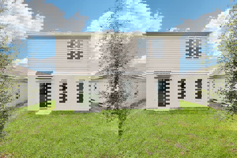 A white house with a green lawn.