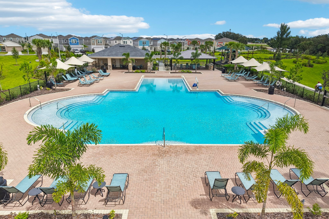 A pool with chairs and umbrellas.