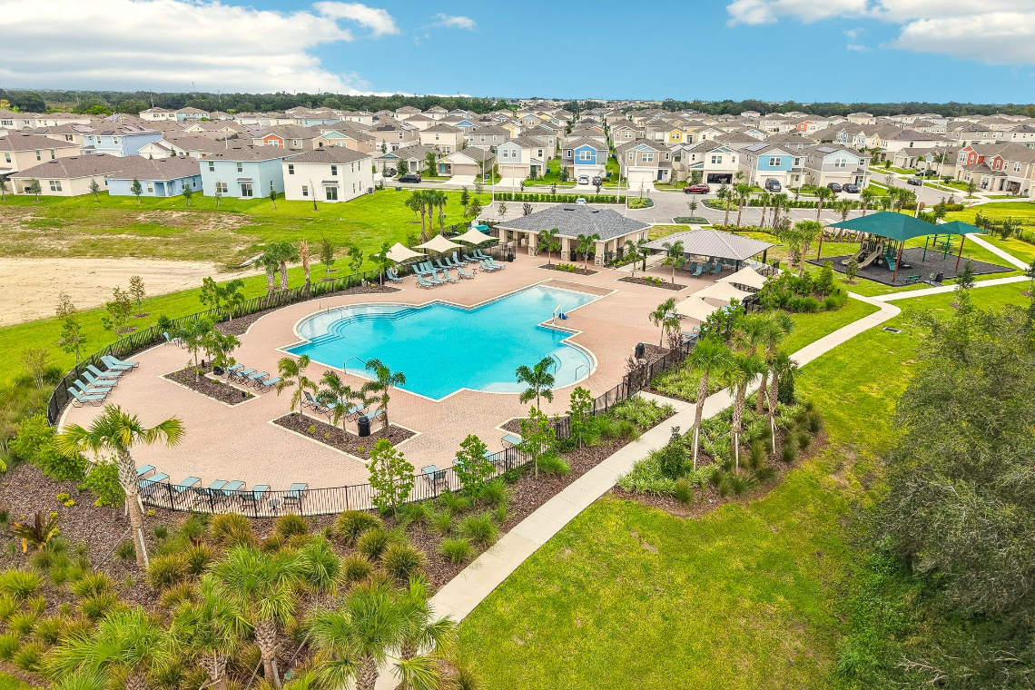 A pool surrounded by trees and buildings.