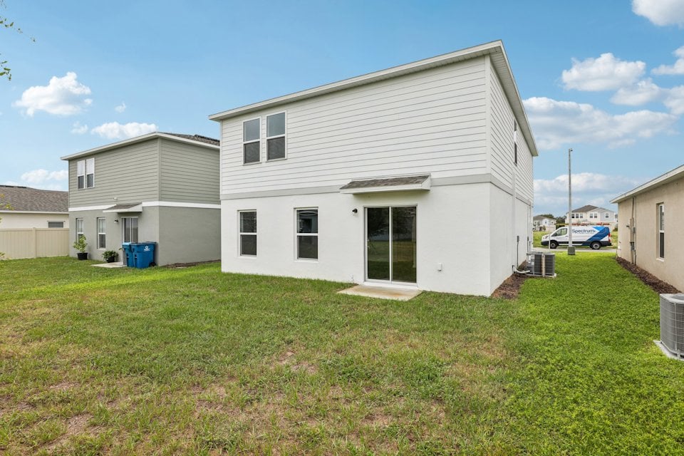 A white house with a green lawn.