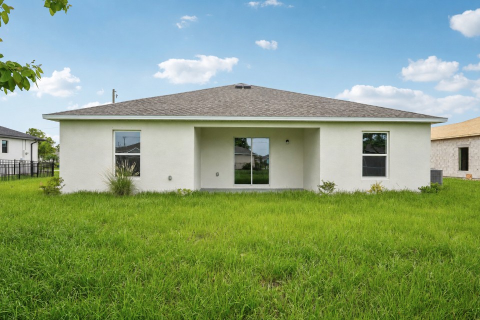 A white house with a grass yard.