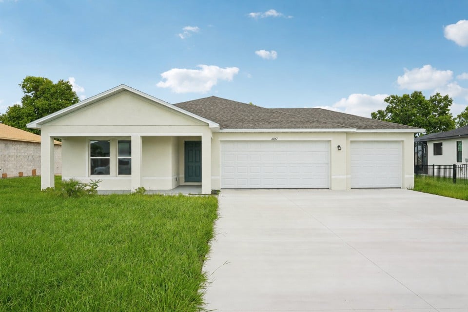 A white house with garages.
