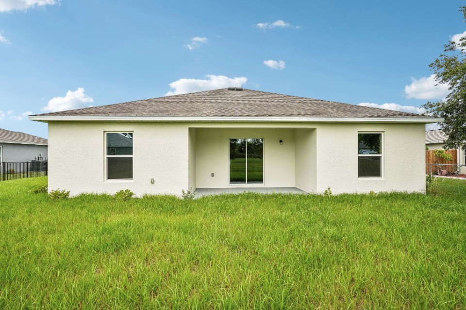 A white house with a grass yard.