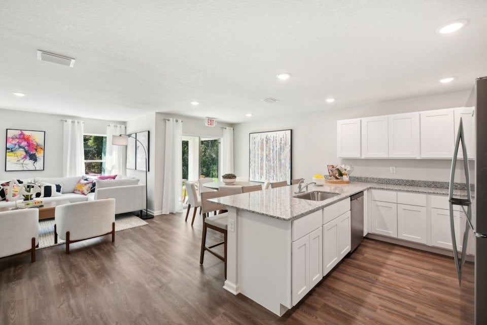 A kitchen with white cabinets.