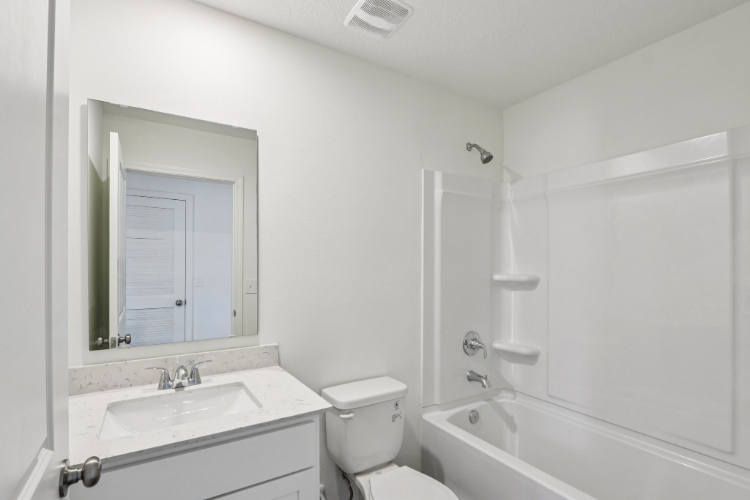 A bathroom with a toilet sink and bathtub.