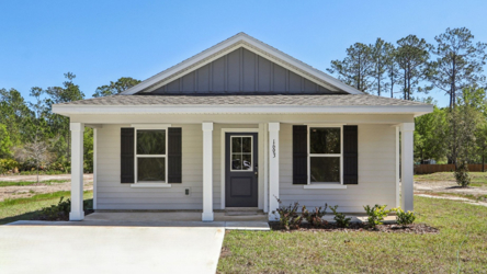 A small white house with Ralph J. Bunche House in the background.