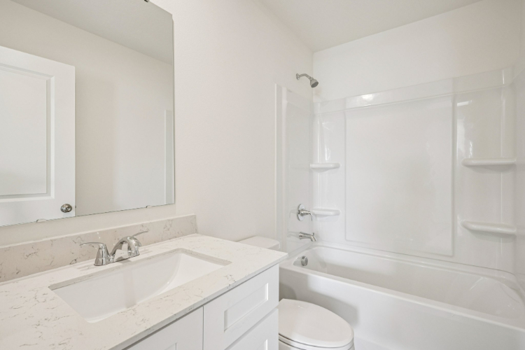 A bathroom with a tub sink and toilet.