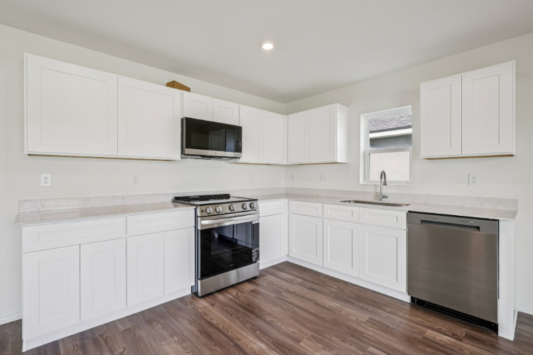 A kitchen with white cabinets.