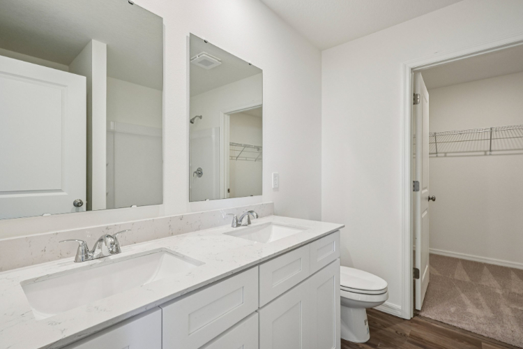 A bathroom with a toilet sink and mirror.