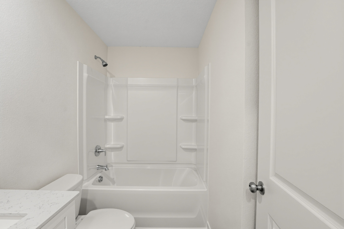 A bathroom with a tub and toilet.