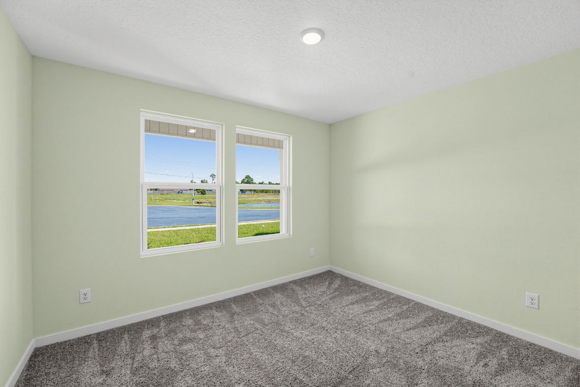 A room with a window and a carpet.