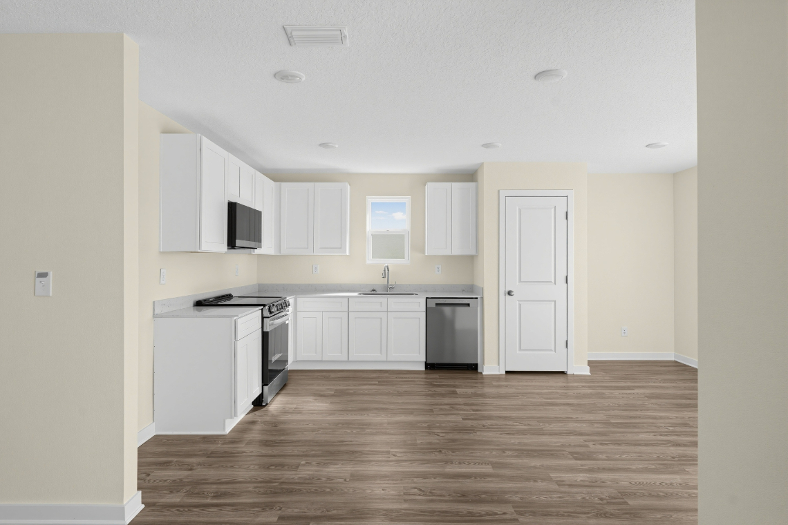 A kitchen with white cabinets.