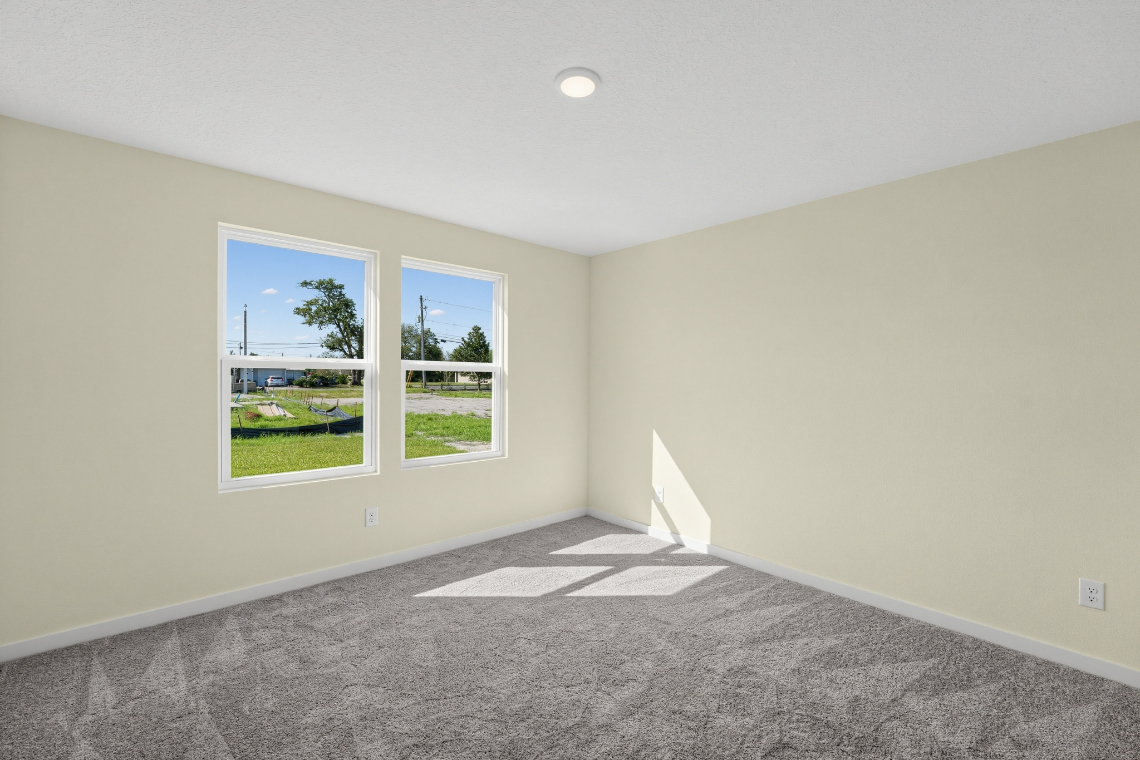 A room with a window and a rug.