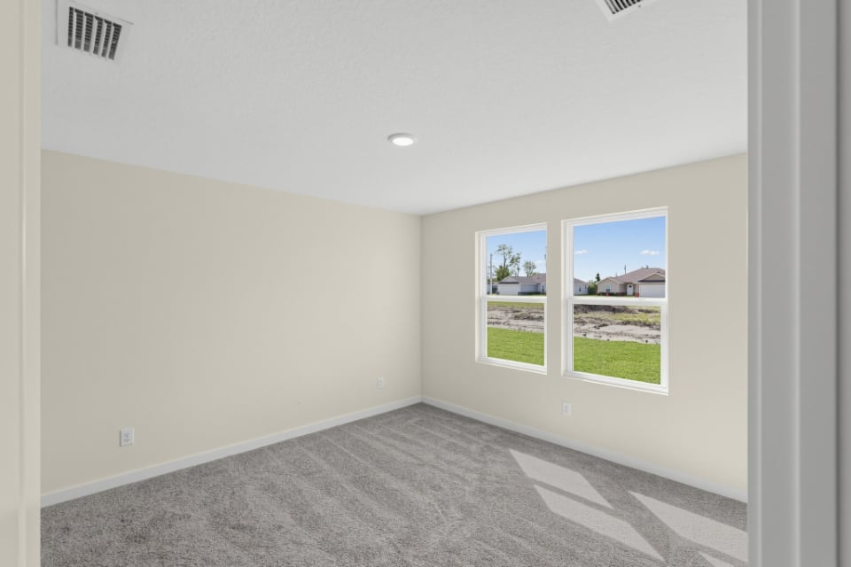 A room with a window and a door with a view of the yard.