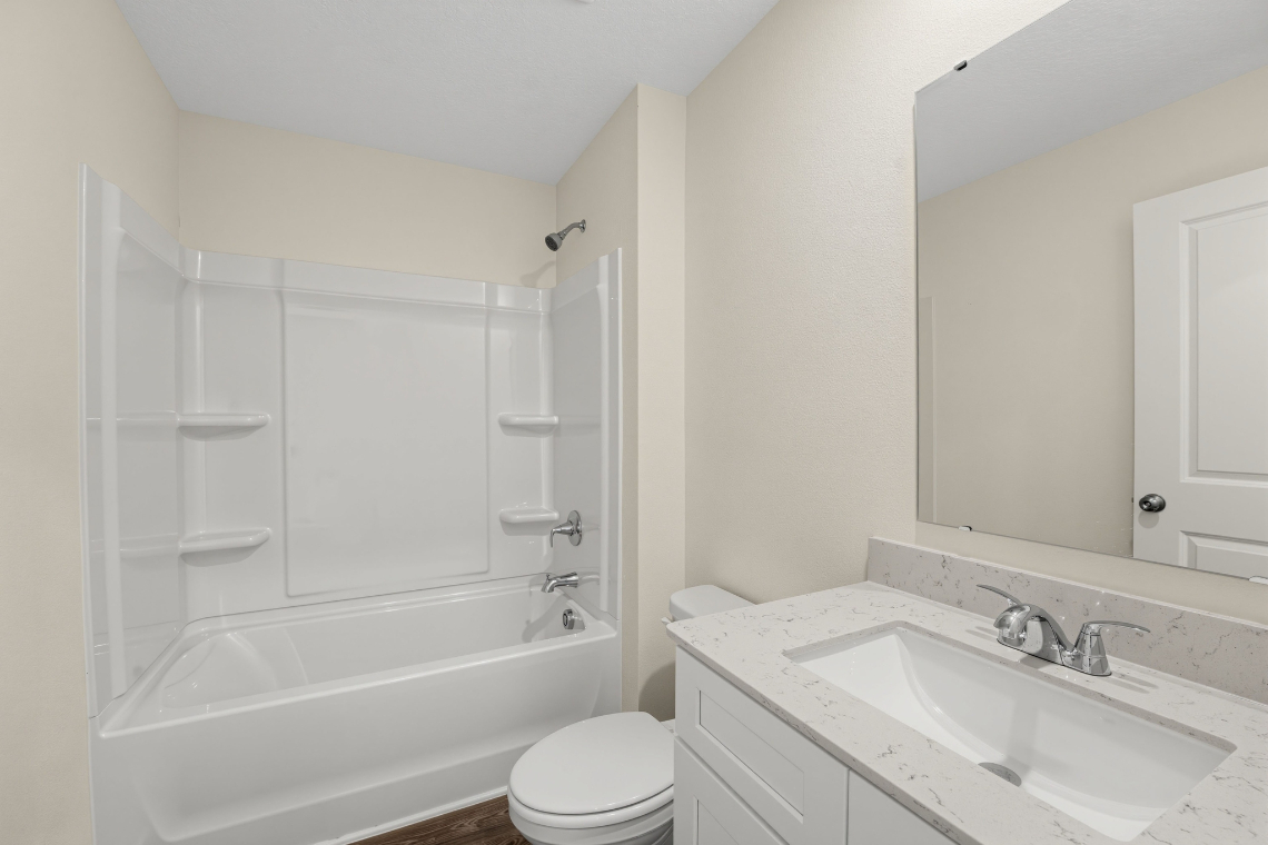 A bathroom with a tub sink and toilet.