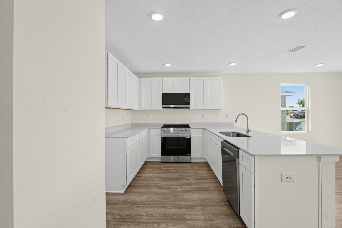 A kitchen with white cabinets.